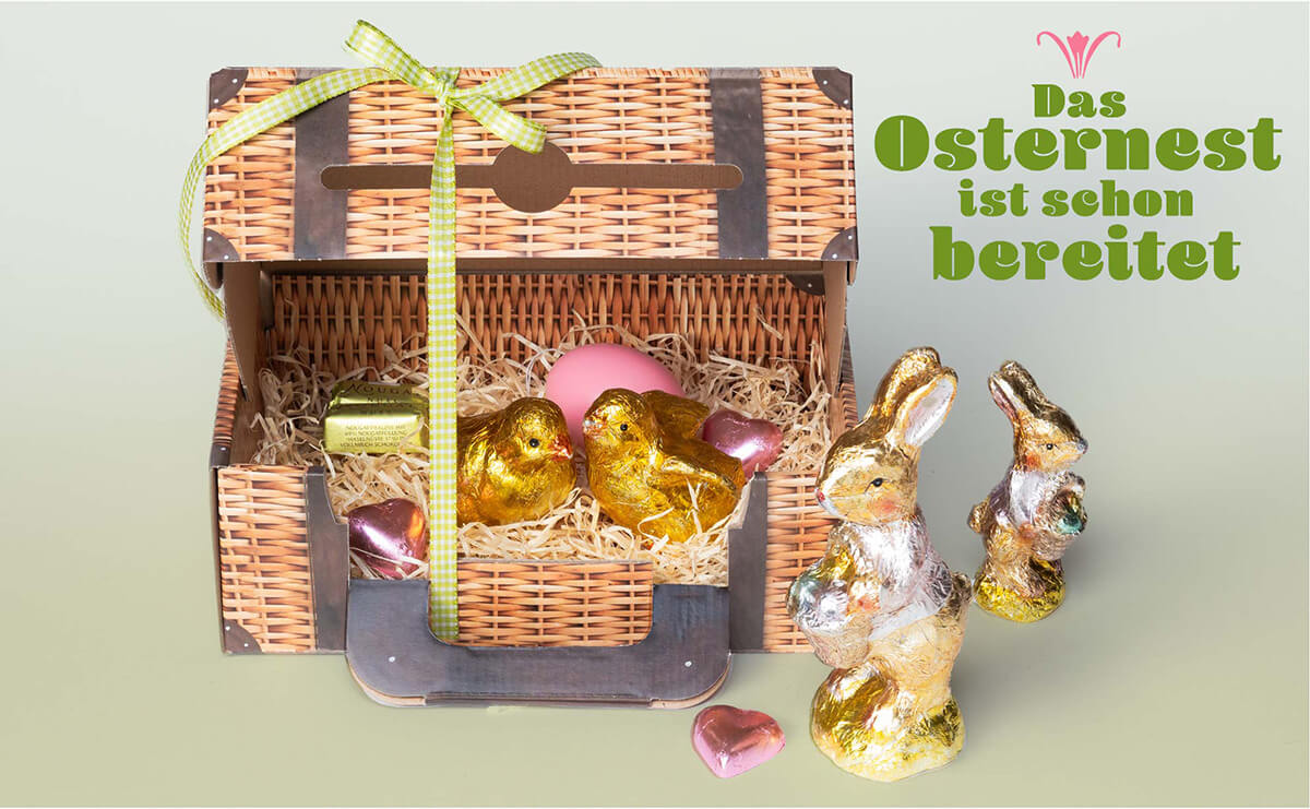 dekorierter Picknickkoffer, gefüllt mit einem Osternest aus Schokoladen